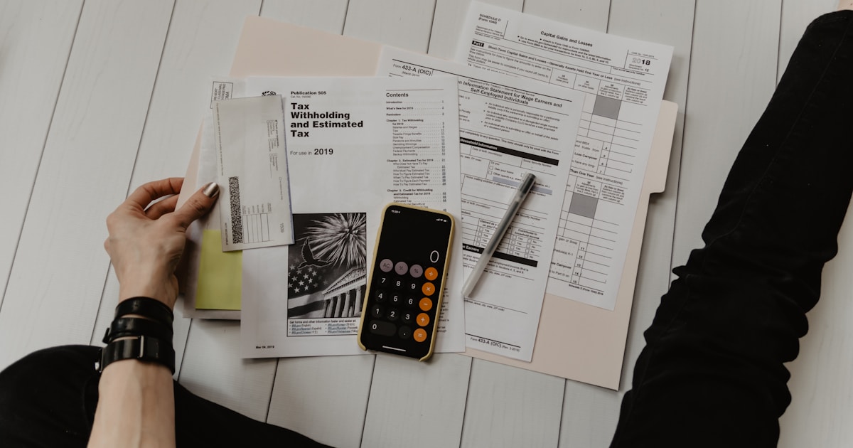 Tax documents, calculator and laptop representing digital nomad tax planning